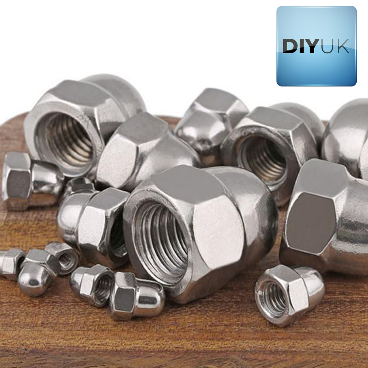 A2 stainless steel dome nuts in several sizes heaped on a wooden surface