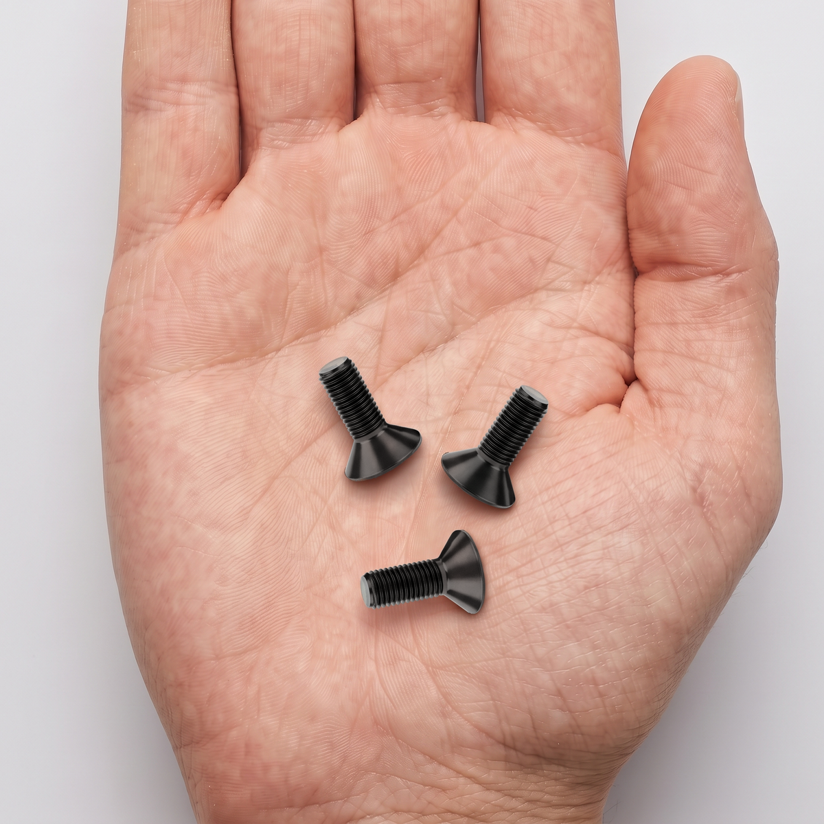 Black Hex Socket Countersunk Bolts - DIN 7991 Grade 10.9, shown in hand for scale