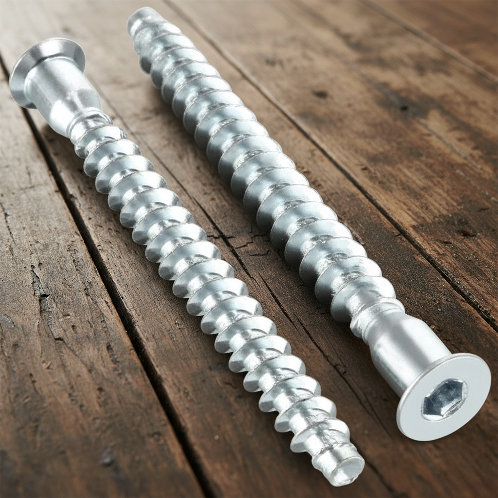 Two confirmat screws with hex socket heads lying on a wooden table
