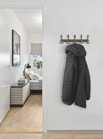 Antique gold coat rack holding a padded jacket in a hallway