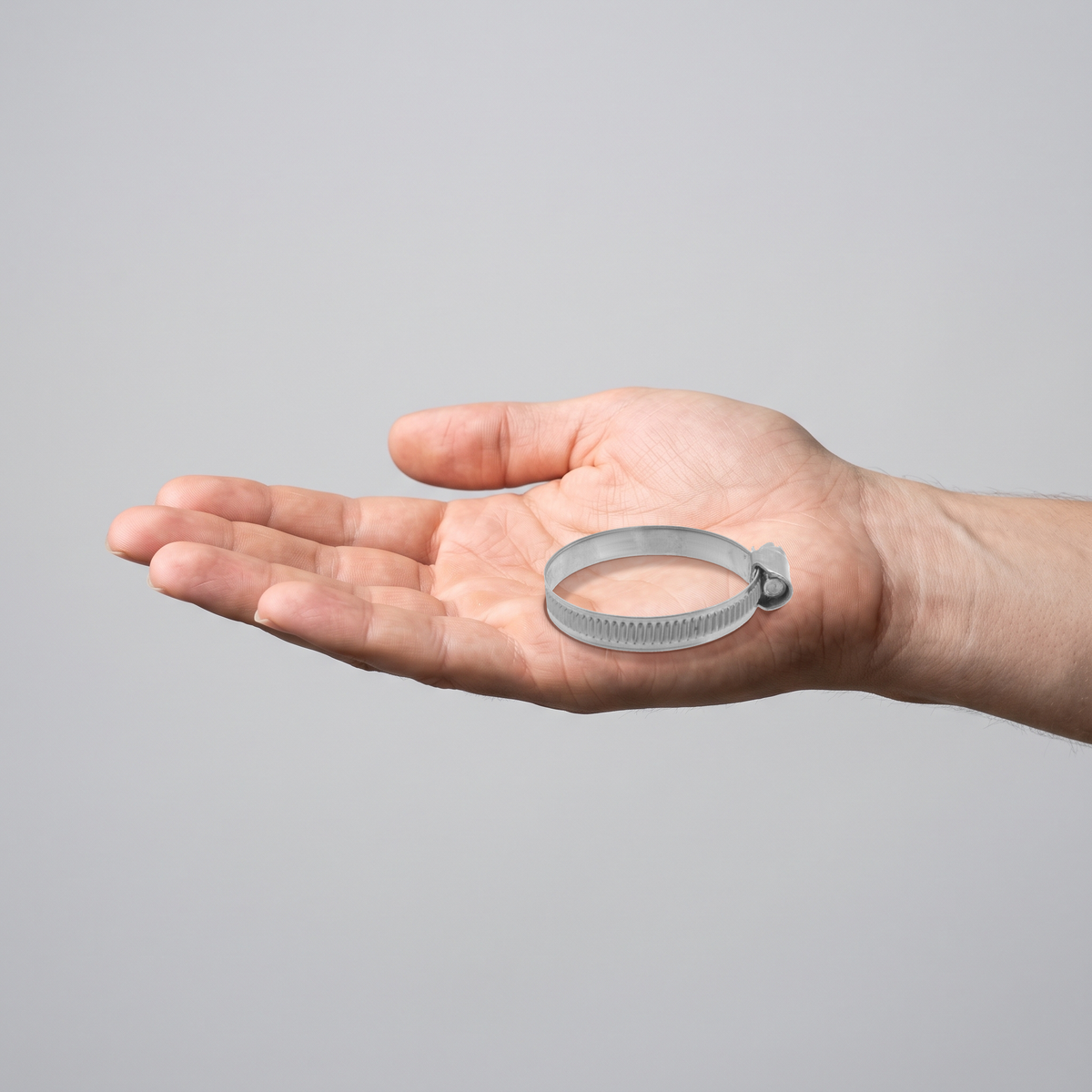 W2 Stainless Steel Worm Drive Hose Clamps - Pipe Clips, shown in hand for scale