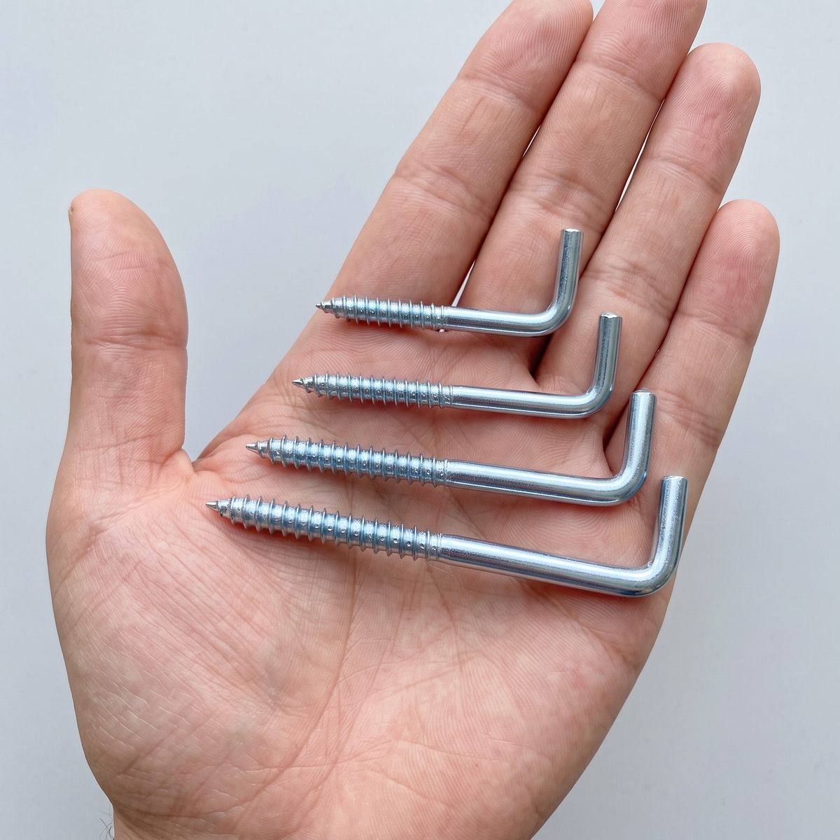 DIYUK Metal L-Hook Screws, Square Cup Hooks, White Zinc-Plated Steel, four sizes shown in hand for scale