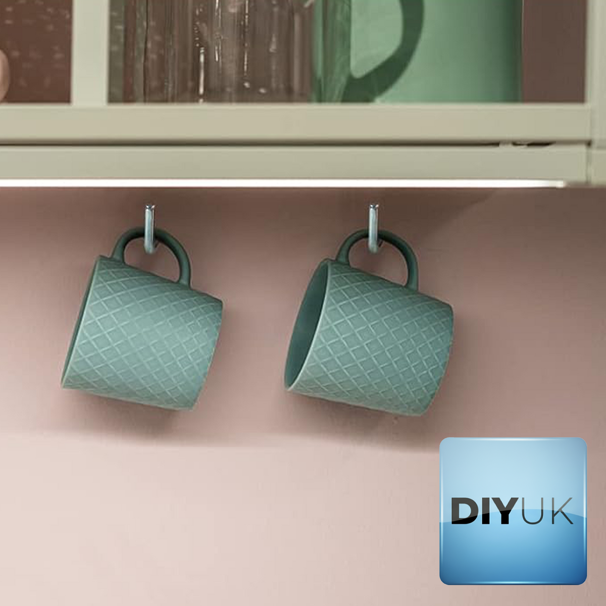Two mugs hanging from white zinc-plated L-hook screws under a kitchen wall unit