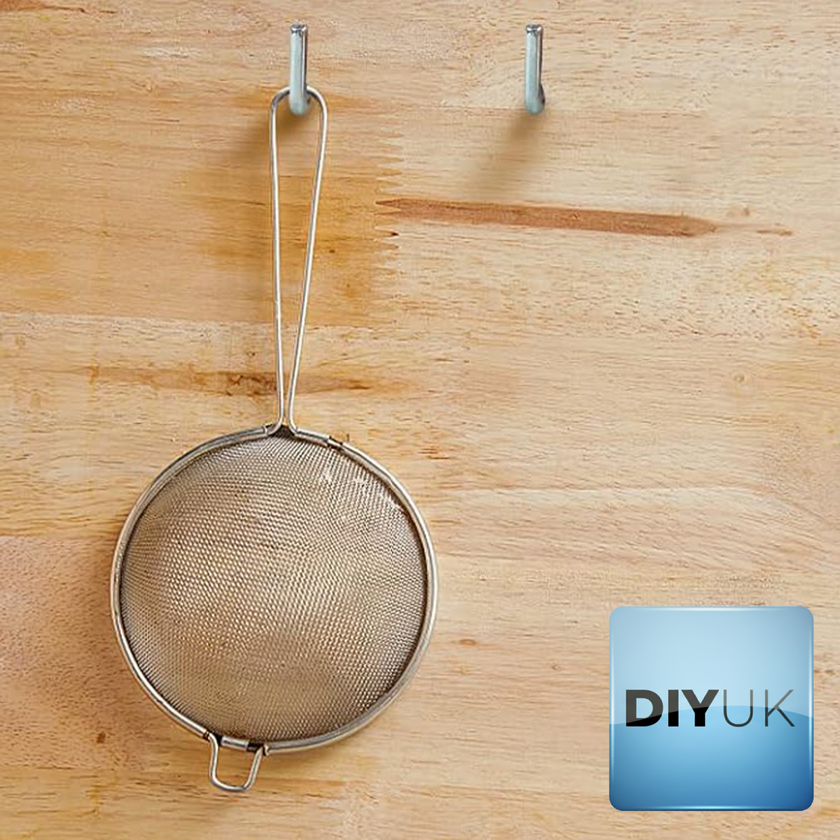 A sieve hanging from a white zinc-plated L-hook screw fixed into timber