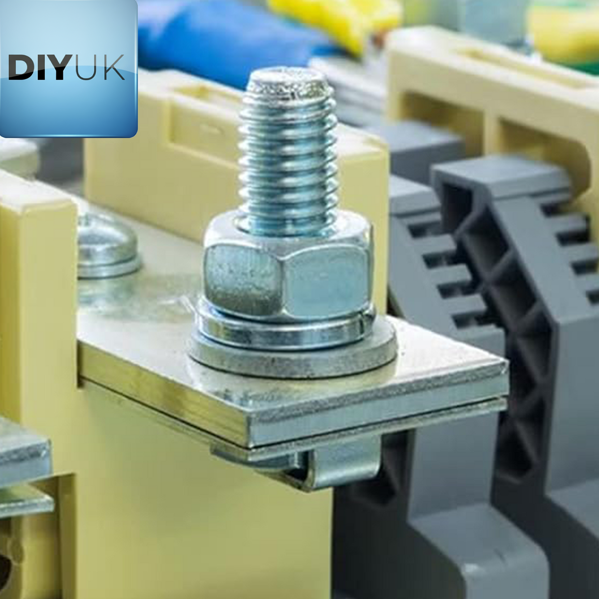 Zinc-plated bolt and nut with flat washers clamping a metal strip on an electrical terminal
