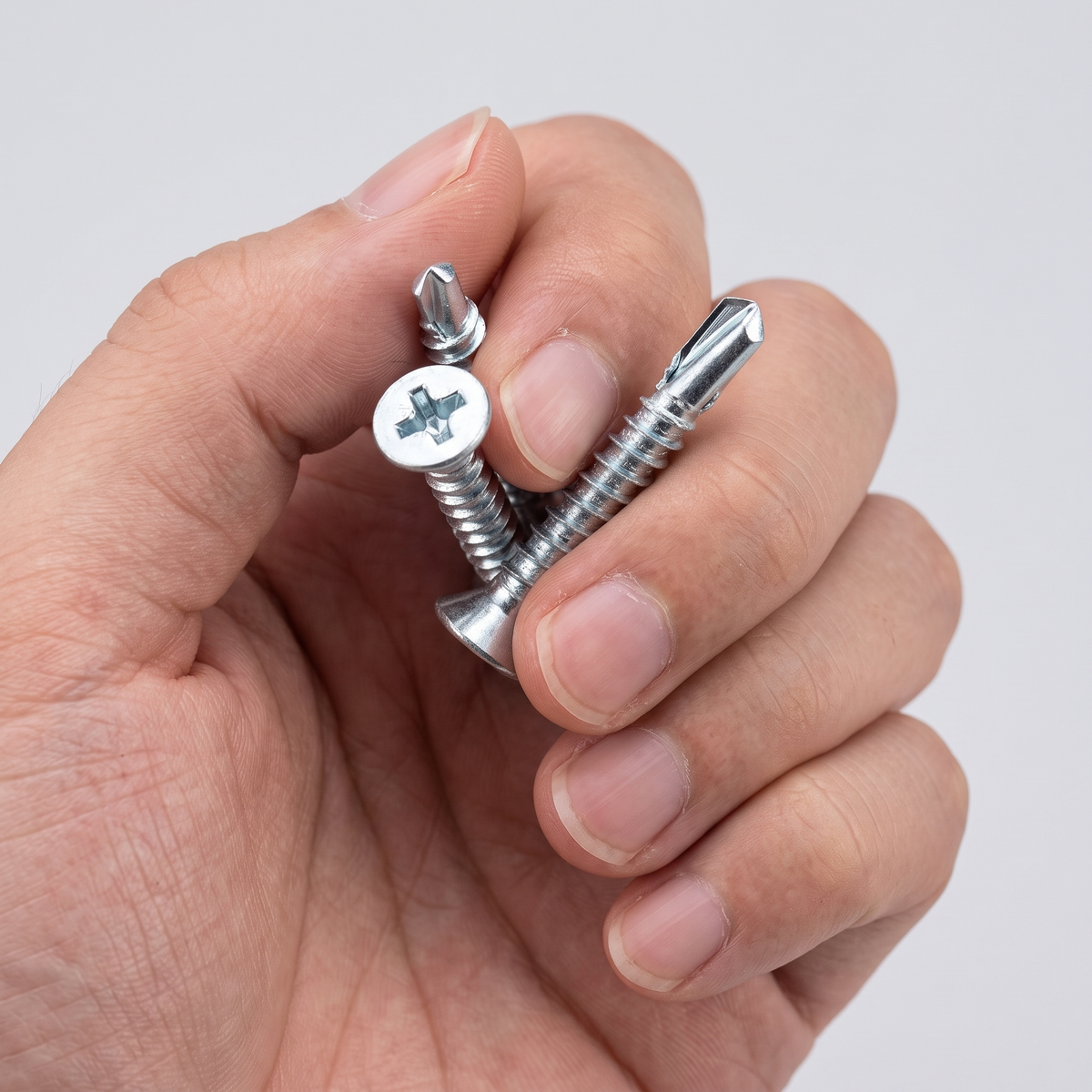 Self-Drilling Countersunk Screws Zinc Plated for Wood, Metal & PVC, shown in hand for scale