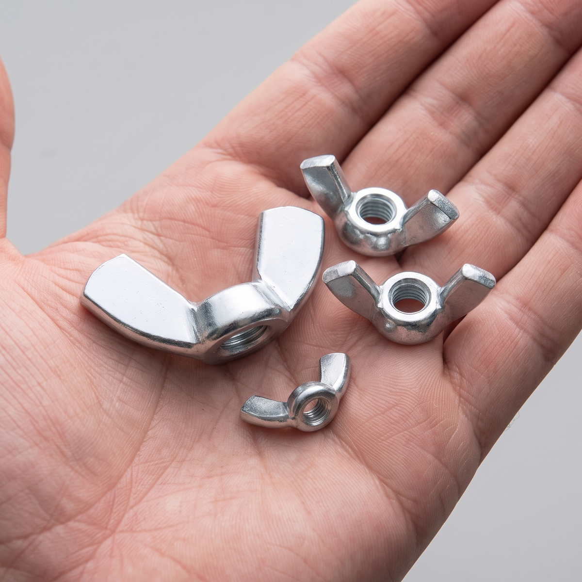 DIYUK Wing Nuts, DIN 315 American Form, shown in hand for scale